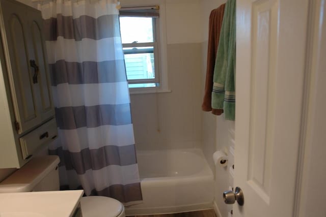 bathroom with vanity, shower / bath combination with curtain, and toilet