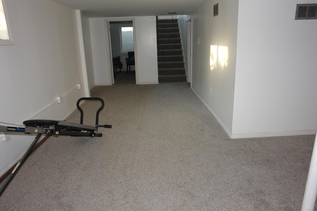 exercise room featuring light carpet, baseboards, and visible vents