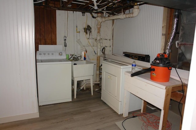 laundry room with laundry area, wood finished floors, and washer and dryer