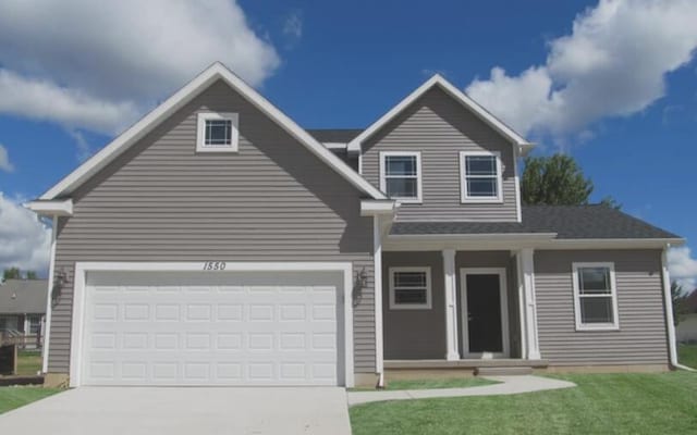 traditional-style house featuring an attached garage, driveway, and a front yard