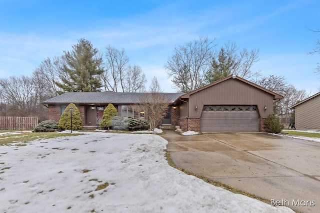 view of front of property with concrete driveway, brick siding, fence, and an attached garage