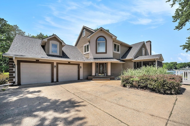 view of front facade featuring concrete driveway, roof with shingles, and an attached garage