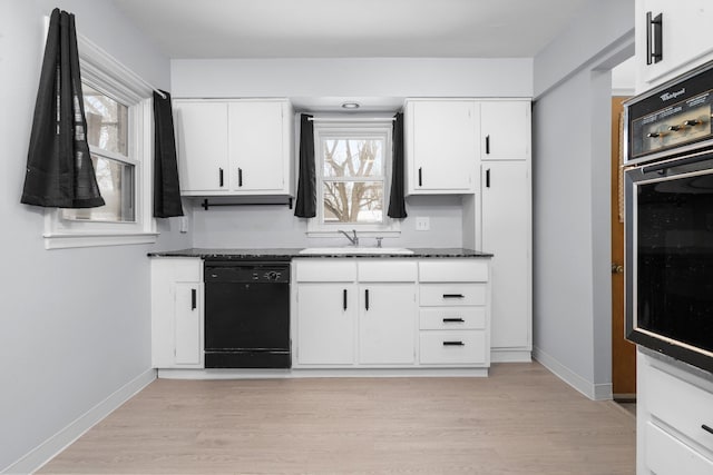 kitchen featuring wall oven, a sink, white cabinetry, black dishwasher, and light wood-type flooring