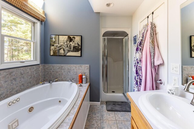 7504 Wiczer Dr, Whitehall, MI 49461 - bathroom featuring a shower stall, a tub with jets, vanity, and tile patterned flooring