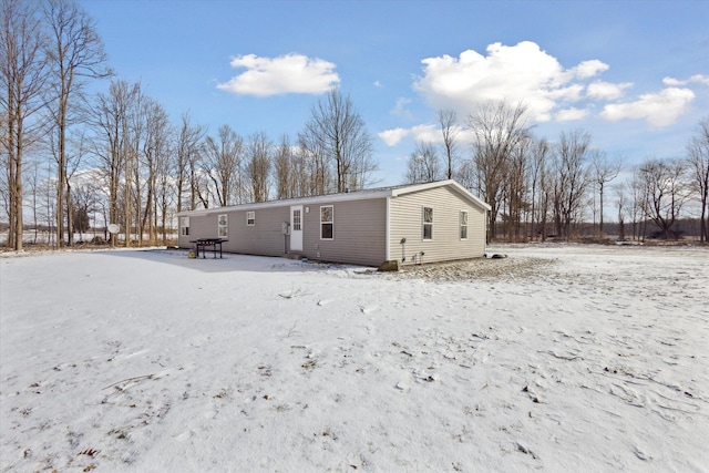 view of snow covered back of property