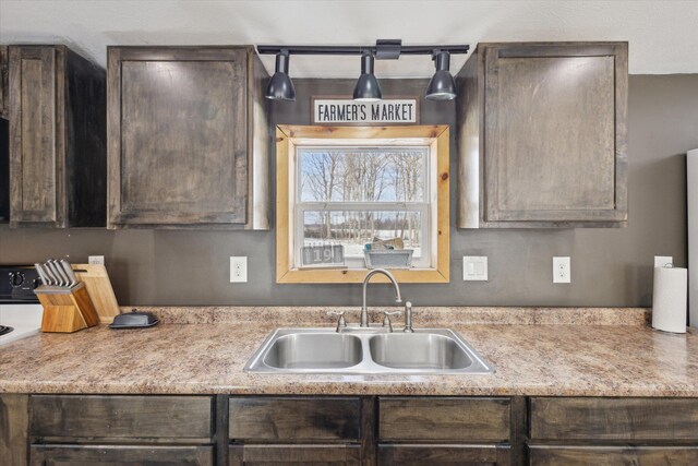 kitchen featuring a sink, dark brown cabinetry, and stove
