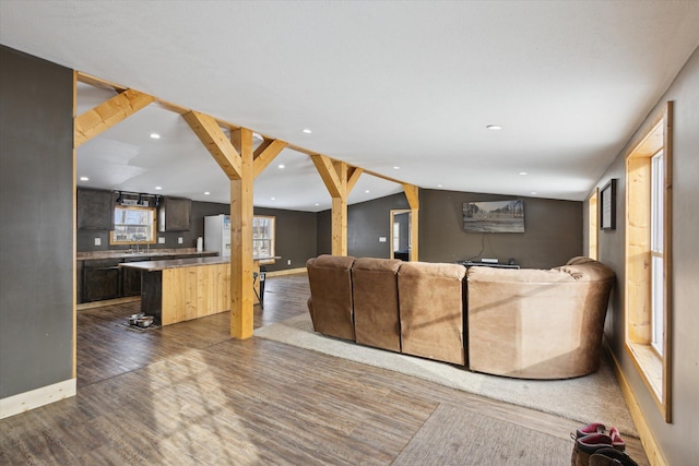 living area featuring lofted ceiling, baseboards, dark wood-style floors, and recessed lighting