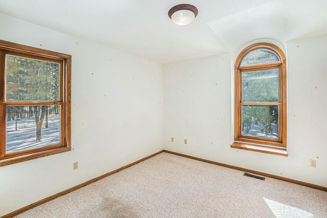 carpeted spare room featuring visible vents and baseboards