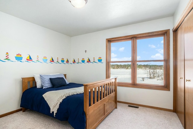 bedroom with visible vents, light carpet, and baseboards