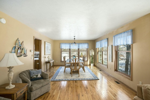 dining room featuring light wood-type flooring, baseboards, and visible vents