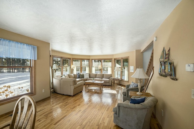 living area featuring light wood-style floors, a healthy amount of sunlight, and a textured ceiling