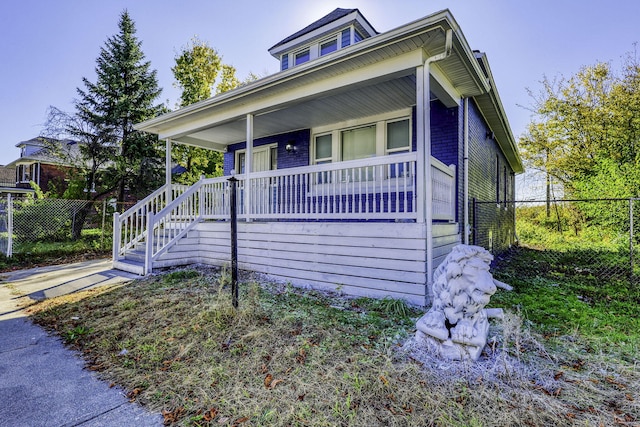 view of front of home with a porch and fence