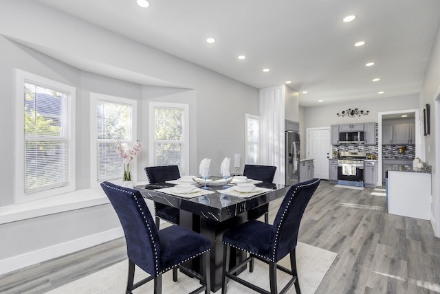 dining room with light wood-type flooring, baseboards, and recessed lighting