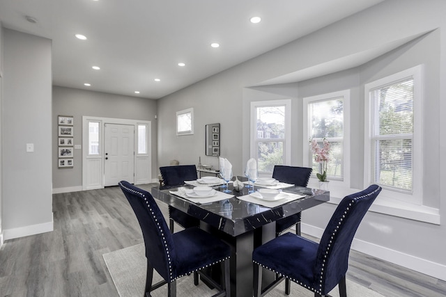 dining space with baseboards, light wood-type flooring, and recessed lighting