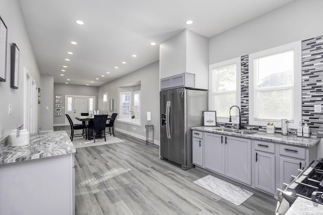 kitchen featuring stainless steel appliances, a healthy amount of sunlight, a sink, and gray cabinetry