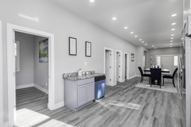 kitchen with light stone countertops, baseboards, light wood-style floors, and recessed lighting