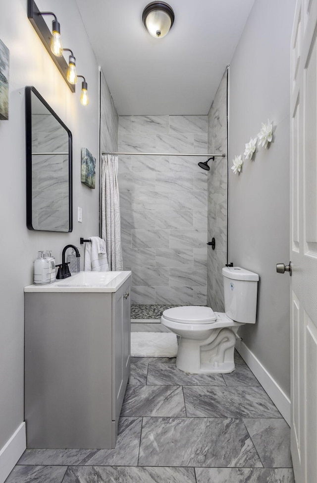 full bath featuring marble finish floor, tiled shower, and toilet