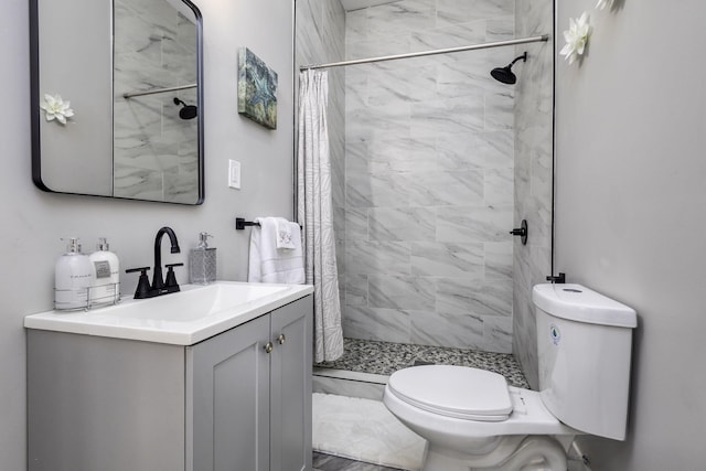 full bath featuring vanity, a shower stall, and toilet