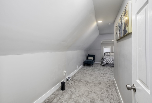 interior space with light carpet, lofted ceiling, visible vents, and baseboards