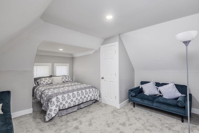 bedroom featuring lofted ceiling, light colored carpet, and baseboards