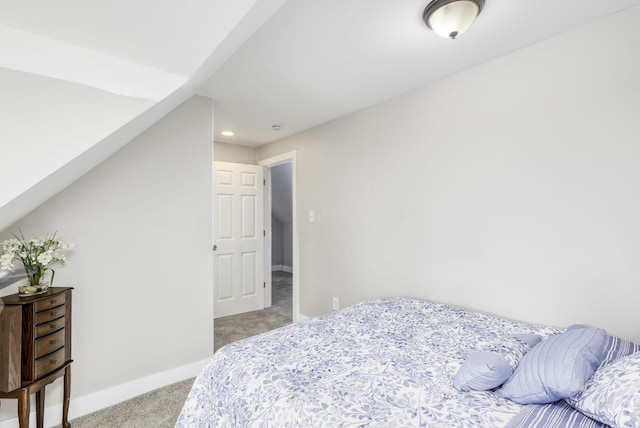 bedroom with baseboards, vaulted ceiling, and light colored carpet