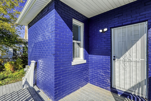 doorway to property with brick siding