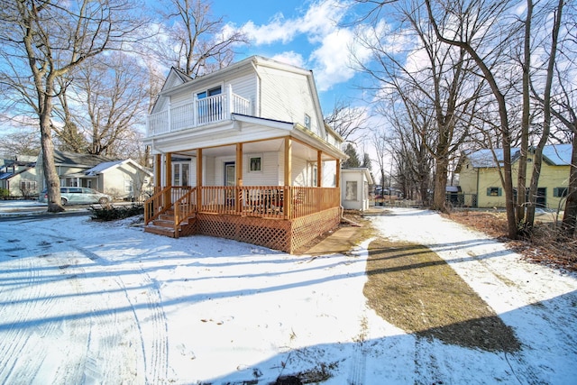 view of front of home with a porch, driveway, and a balcony