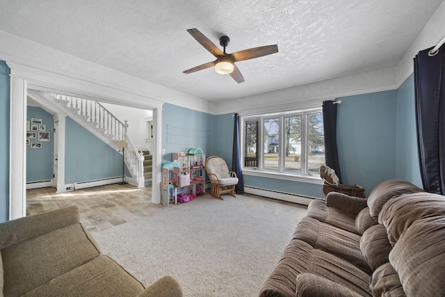 interior space with a ceiling fan, stairway, and baseboard heating