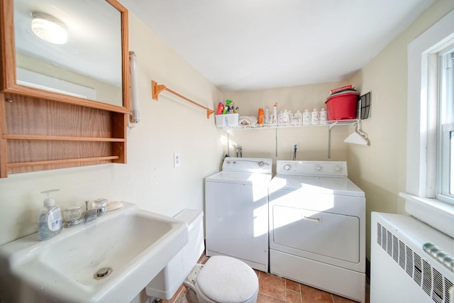 laundry room with washer and dryer, laundry area, a sink, and radiator heating unit