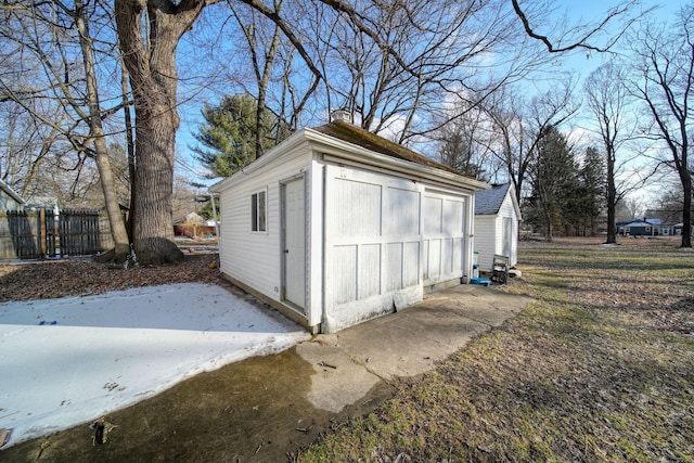 view of outbuilding with fence and an outbuilding