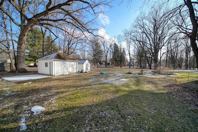 view of yard with a garage and an outbuilding