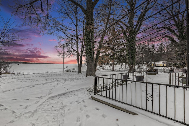 yard layered in snow with a water view