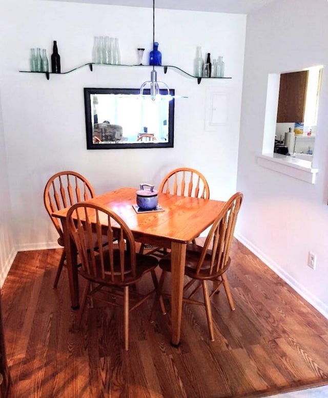 dining room featuring an inviting chandelier, baseboards, and wood finished floors