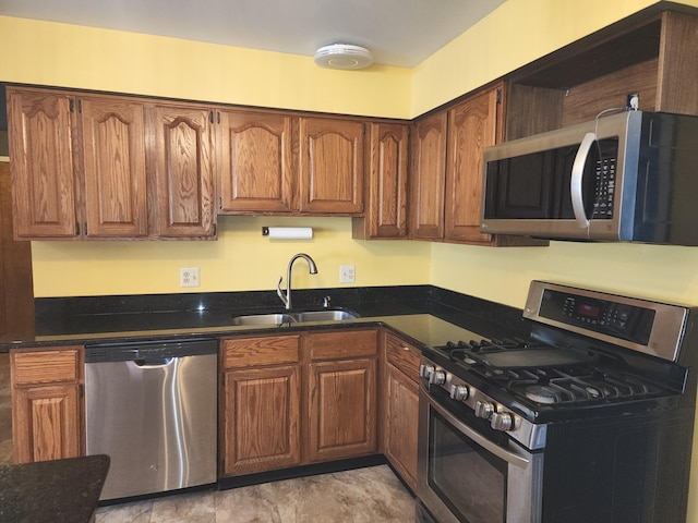 kitchen featuring open shelves, brown cabinetry, stainless steel appliances, and a sink