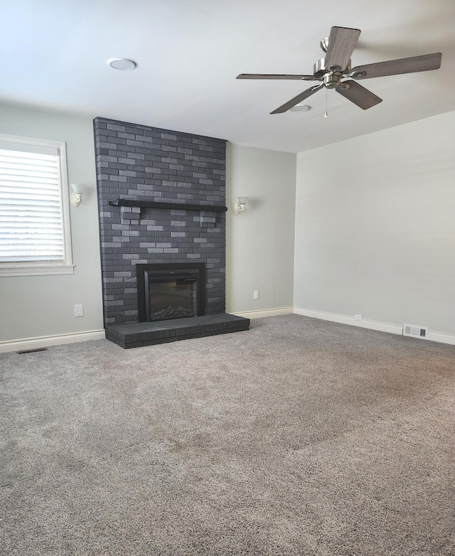 unfurnished living room featuring carpet floors, visible vents, a fireplace, and baseboards