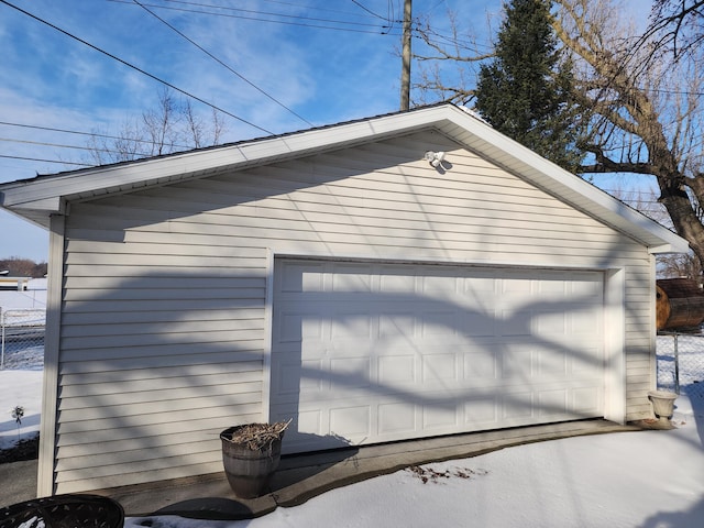 snow covered garage with a garage