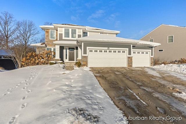 prairie-style home featuring a garage, stone siding, and driveway