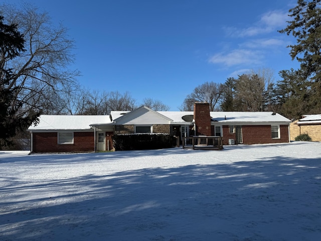 view of front facade featuring brick siding and a chimney