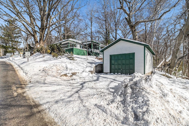 snow covered garage featuring a garage