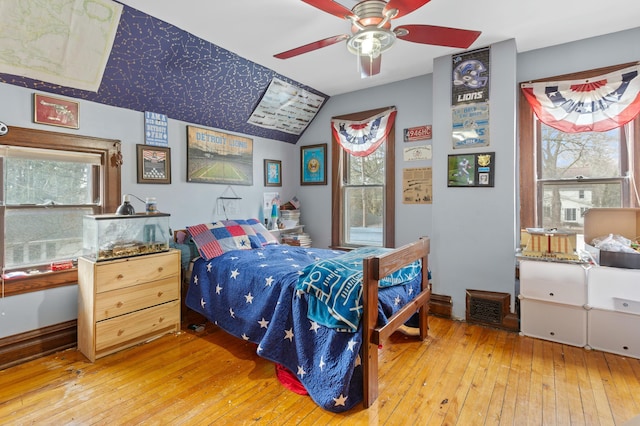 bedroom with lofted ceiling, light wood-style floors, and multiple windows