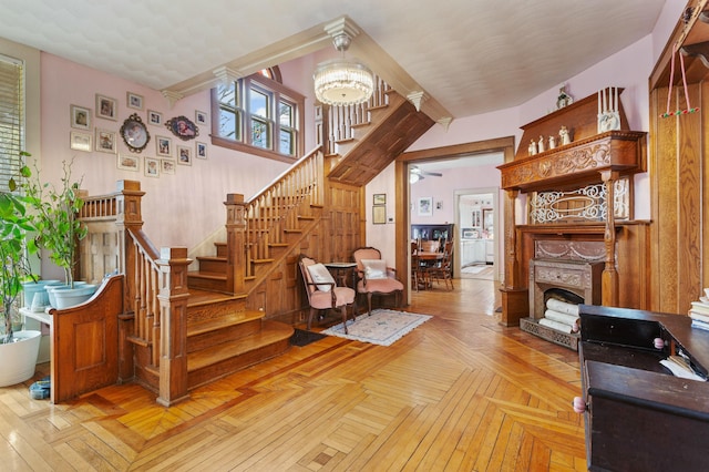 living area with a chandelier, stairway, and a fireplace