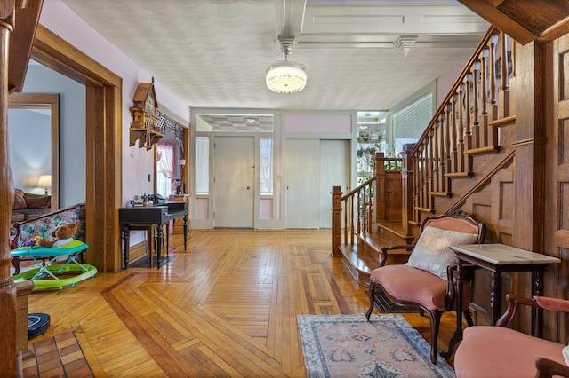 foyer entrance with a wealth of natural light, a textured ceiling, and stairs