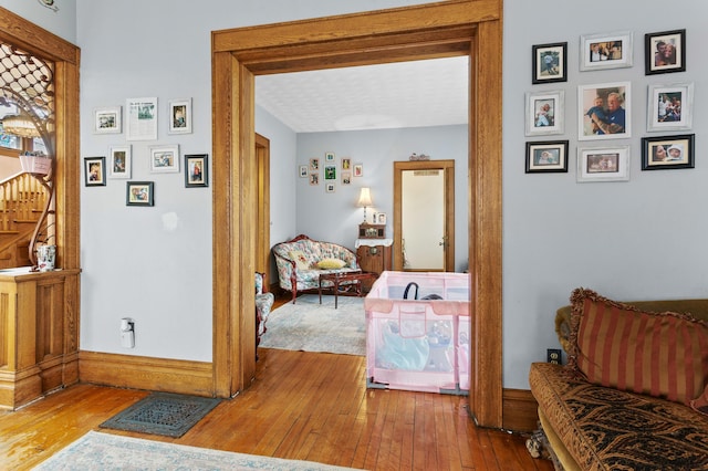 sitting room with wood-type flooring, visible vents, and baseboards