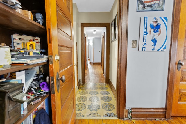 hallway featuring hardwood / wood-style floors and baseboards