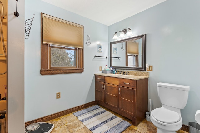 full bathroom with baseboards, vanity, and toilet