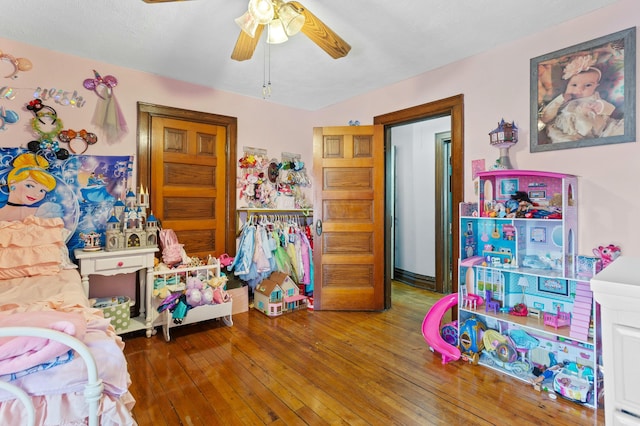 rec room with hardwood / wood-style floors and a ceiling fan