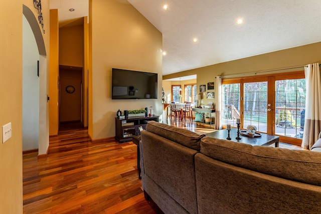 7016 Hyde Park Rd, Whitehall, MI 49461 - living room with wood finished floors, high vaulted ceiling, french doors, arched walkways, and recessed lighting