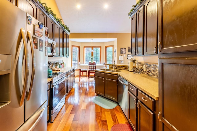 7016 Hyde Park Rd, Whitehall, MI 49461 - kitchen with stainless steel appliances, a sink, light wood finished floors, light countertops, and a peninsula