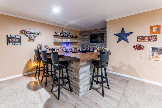 7016 Hyde Park Rd, Whitehall, MI 49461 - indoor dry bar featuring ornamental molding, baseboards, and light wood-type flooring