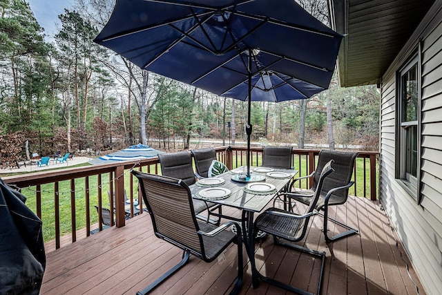 7016 Hyde Park Rd, Whitehall, MI 49461 - wooden deck featuring outdoor dining space and a lawn